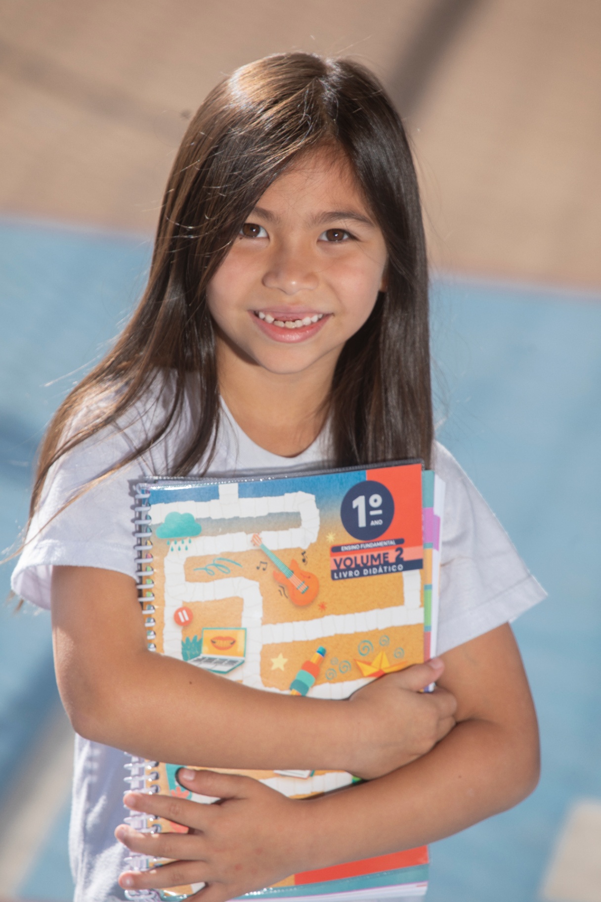 Aluna do 1º ano sorrindo com livro